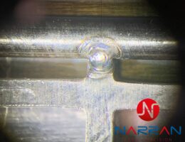 Zblízka zachycený dokončený laserový svar na nerezovém materiálu.